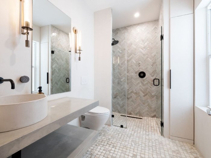 Modern bathroom with light grey tile floors and shower walls